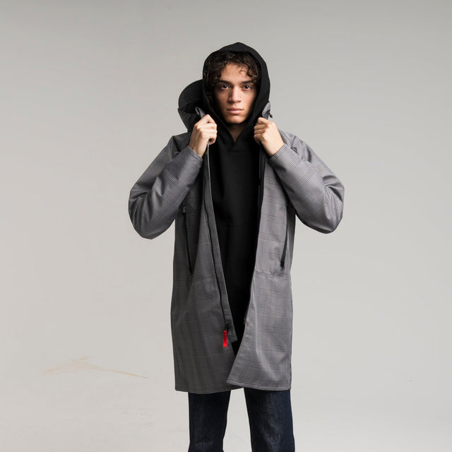 Person wearing a gray coat with a hood on a white background