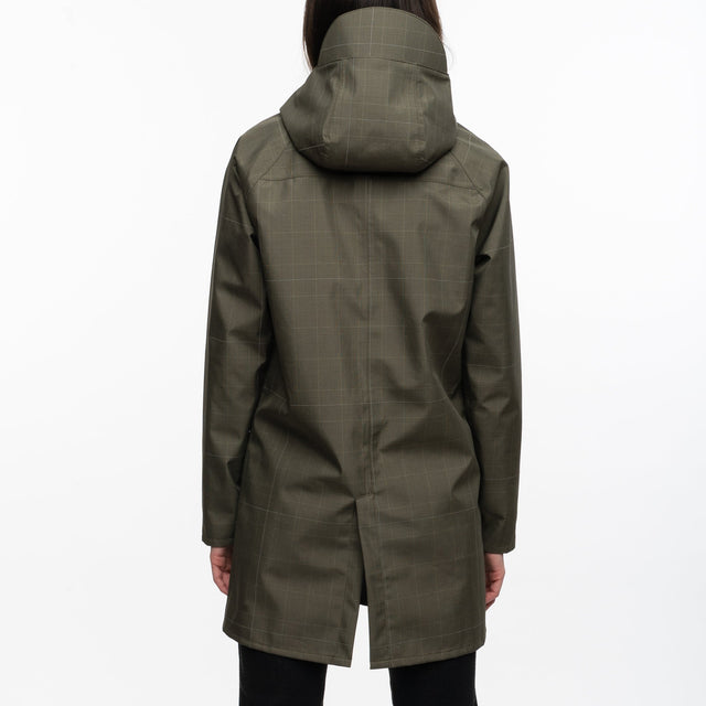 Person wearing a green raincoat standing on a white background