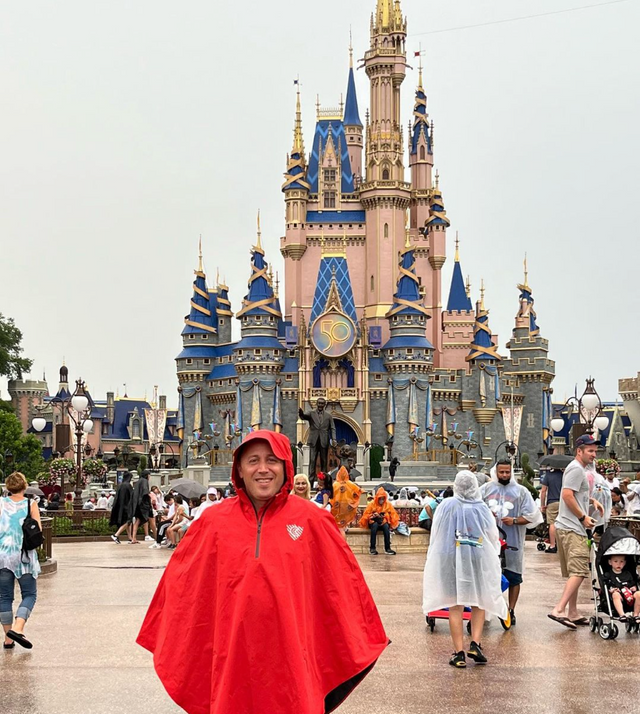 Cleverhood Red Rover Rain Cape at Disney World in front of Cinderella Castle