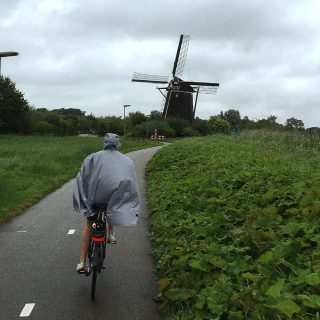 Cleverhood Gingham Urbanaut Rain Cape on bike in front of old wooden windmill