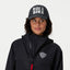 Person wearing a black jacket with a logo and a cap with 'RIDE A BIKE' text on a white background