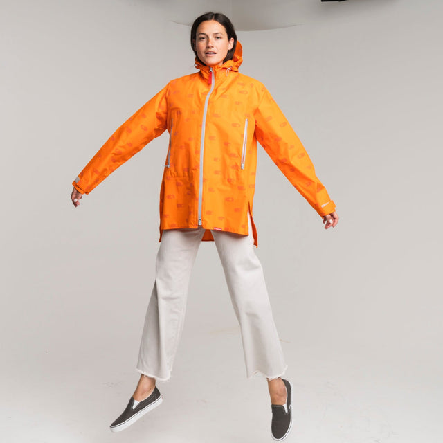 woman wearing an orange raincoat on a white background