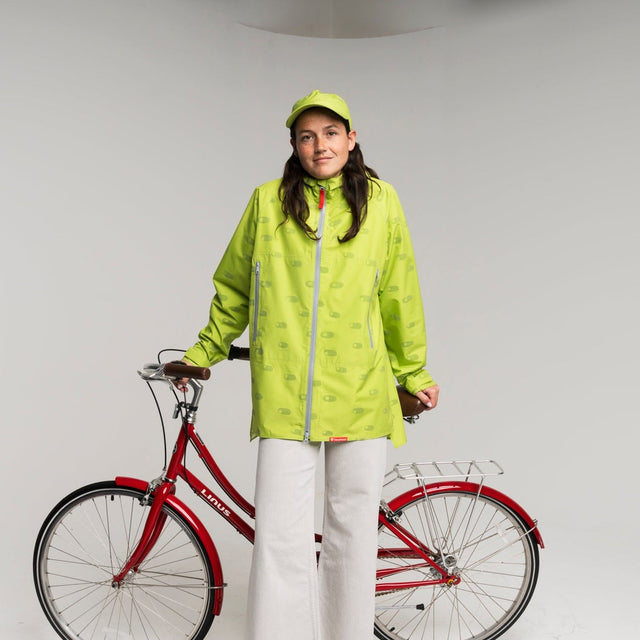 Person wearing a bright green raincoat standing next to a red bicycle on a white background