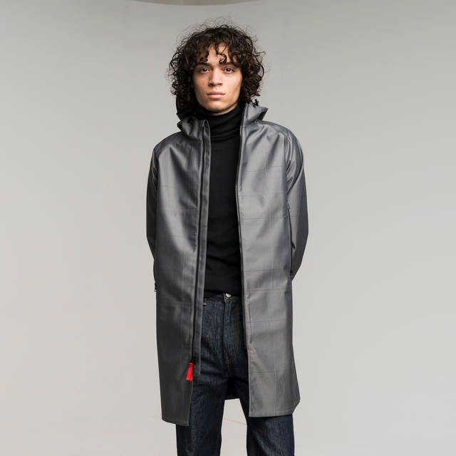 Man wearing silver trench coat on a white background